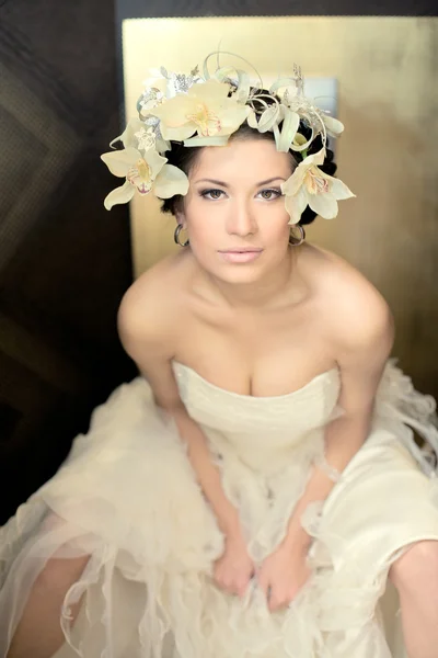 Beautiful bride brunette with flowers in hairs in a sexual pos