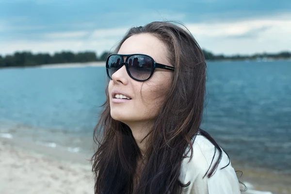 Giovane bella ragazza in occhiali da sole su una spiaggia — Foto Stock