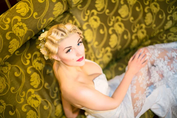Retrato de una hermosa chica en un vestido blanco en un sofá amarillo — Foto de Stock