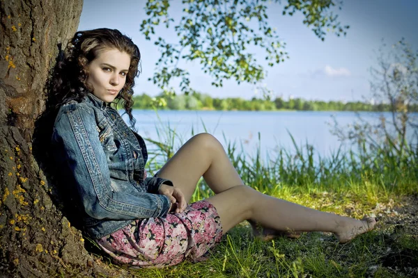 Krásná mladá žena relaxační poblíž řeky — Stock fotografie