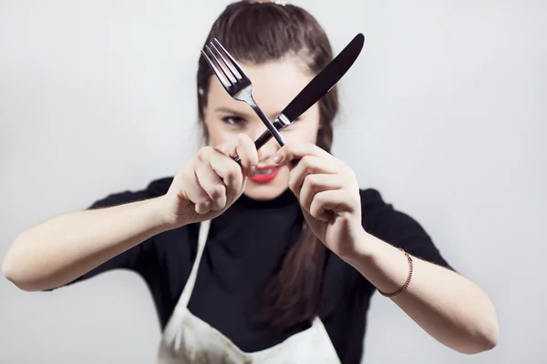 Una joven muy linda sosteniendo utensilios de cocina —  Fotos de Stock