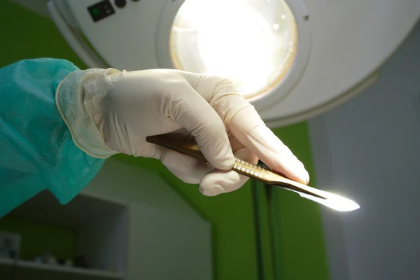 Скальпель в руке хирурга — стоковое фото