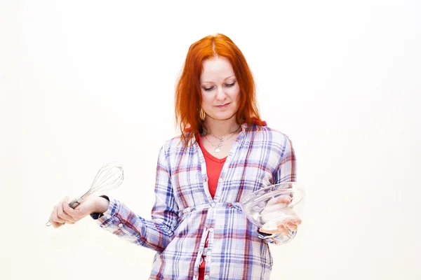 Punapää nuori nainen kokkaa illallista — kuvapankkivalokuva