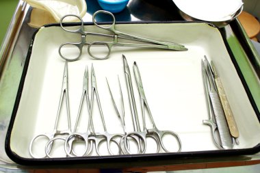 Surgical instruments in a steel tray clipart