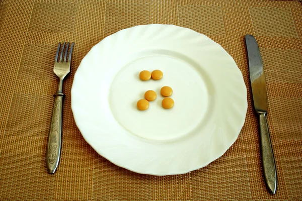 Таблетки на белой тарелке — стоковое фото