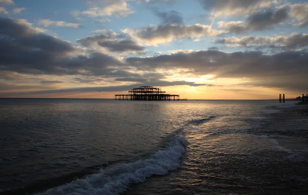 Brighton jetée vagues coucher de soleil — Photo