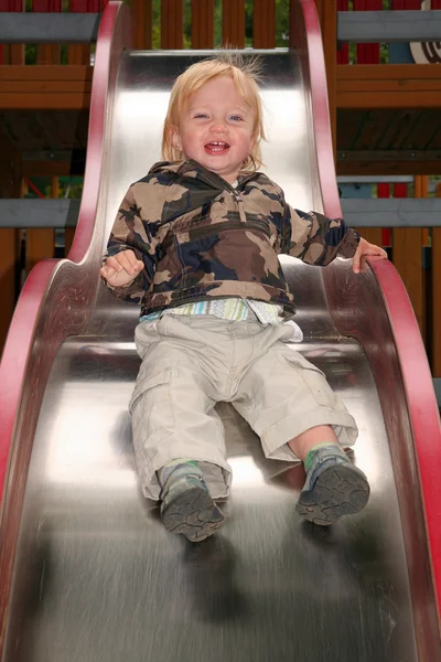 Niño diapositiva paseo parque infantil — Foto de Stock