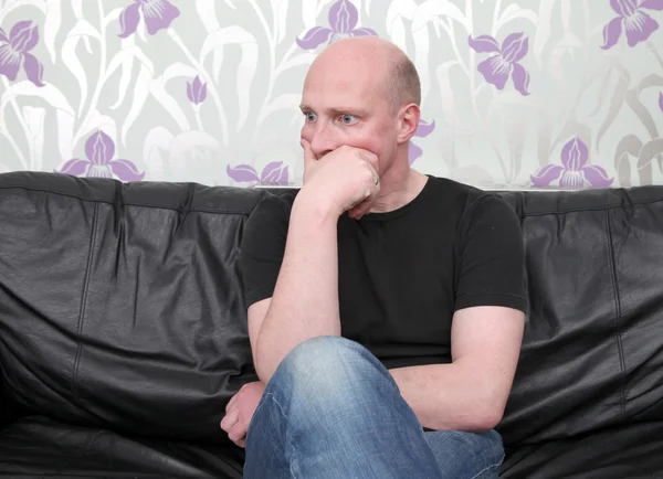 Mann mit Sofa-Gedanken schockiert — Stockfoto