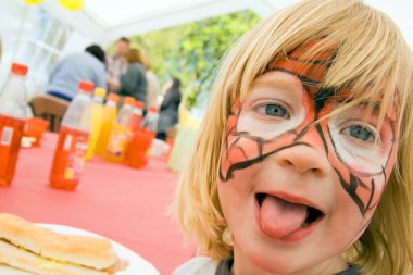 Face paint on child at birthday party celebration. boy kid pretend to be tiger or spideman clipart