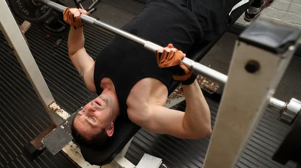 在健身房健身锻炼 男举杠铃 训练上肢力量练习设备下的男人 — 图库照片