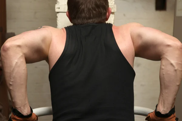 トレーニング上腕二頭筋と上腕三頭筋のジムで 筋肉を示す彼自身を持ち上げる人運動 — ストック写真