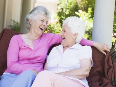 Senior female friends laughing together clipart