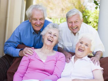 Group of friends relaxing sitting on garden seat clipart