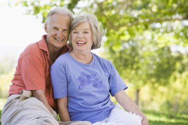 Senior couple relaxing in park clipart