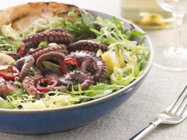 Bowl of Baby Octopus Salad with Frisse Roquette and Chargrilled Bread clipart