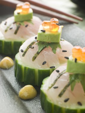 Dish of Sashimi Of Sea bass with Avocado and Salmon Roe with chopsticks clipart