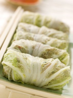 Plate of Steamed Pork and Vegetable Cabbage Rolls With Sweet Chili Sauce clipart