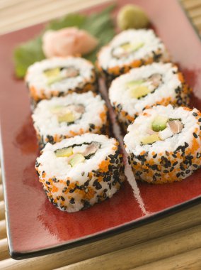 Plate of Inside-out Sushi Rolls decorated with roe and sesame seeds clipart