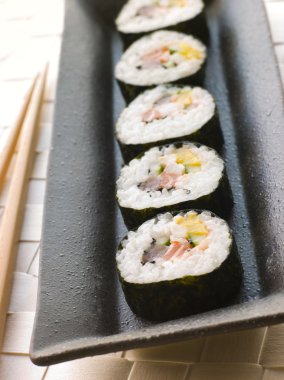 Plate of Large Spiral Rolled Sushi with chopsticks clipart