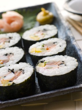 Plate of Large Spiral Rolled Sushi with Sushi Ginger Wasabi and Soy Sauce garnish clipart