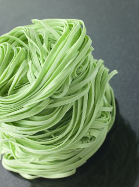 Close up of Stack of Spinach Noodles on a Black Background clipart