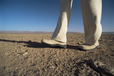 Man walking in desert, low section, , clipart