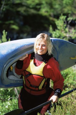 Young woman carrying kayak clipart