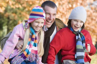 Father and children on autumn walk clipart