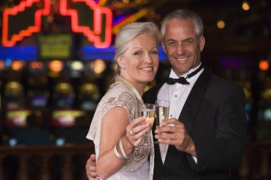Mature couple celebrating in casino clipart