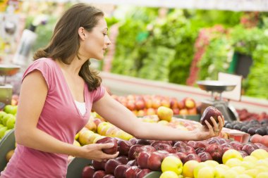 Woman shopping in produce department clipart