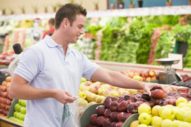 Man shopping in produce setion of supermarket clipart