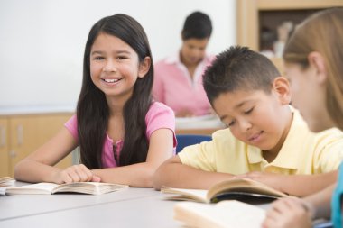 Group of elementary school pupils reading clipart