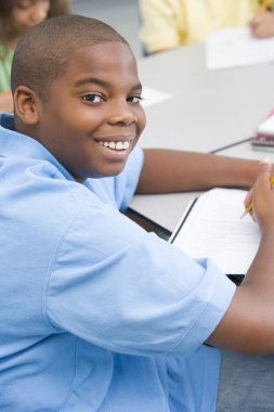 Elementary school pupil working at desk clipart