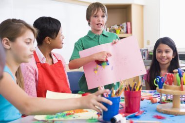 Elementary pupil discussing picture with classmates clipart