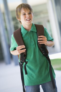 Elementary school pupil outside with rucksack clipart