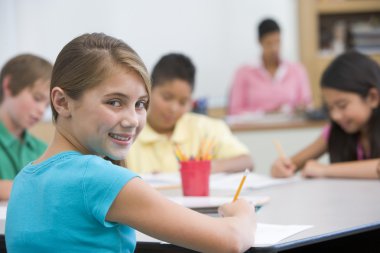 Female elementary pupil in school classroom clipart