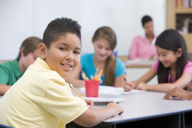 Elementary school pupil in classroom clipart