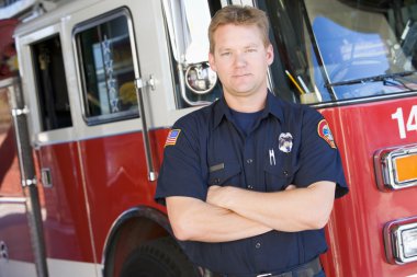 Portrait of a firefighter by a fire engine clipart