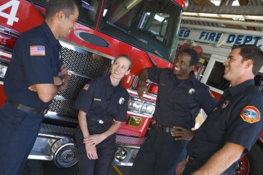 Firefighters chatting by a fire engine clipart