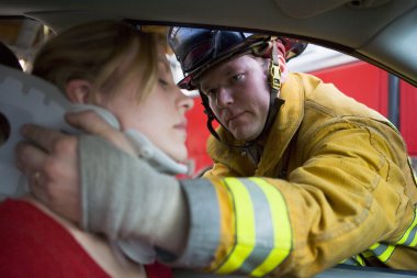 Firefighters helping an injured woman in a car clipart