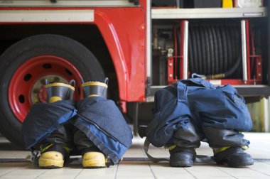 Firefighter's boots and trousers in a fire station clipart