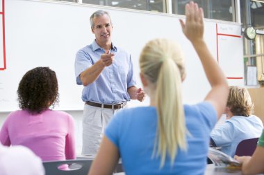 A teacher talks to school children in a high school class clipart