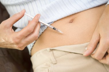 Close up of woman injecting drugs to prepare for IVF treatment clipart