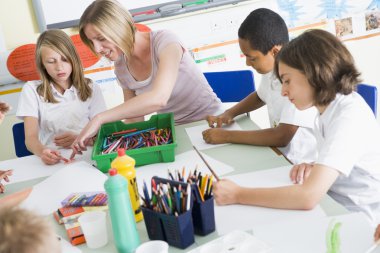 Schoolchildren and their teacher in an art class clipart