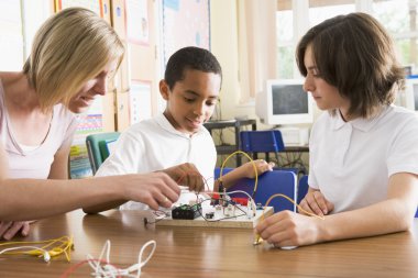 Schoolchildren and their teacher in a science class clipart