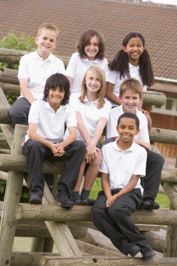 School children sitting on benches outside clipart