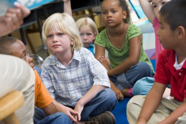 Kindergarten children listening to a story clipart