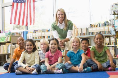 Kindergarten teacher sitting with children in library clipart