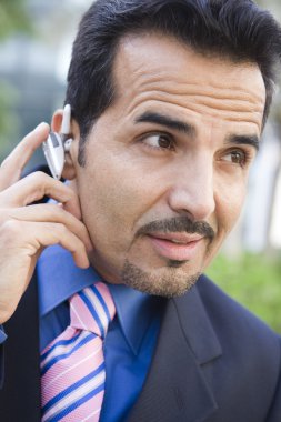 Businessman using bluetooth earpiece clipart