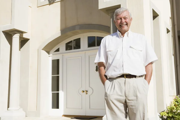 Senior man standing outside house — Stock Photo, Image